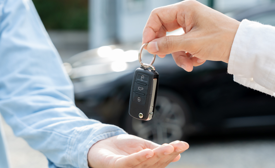 1 Mann reicht einem anderen einen Schlüssel für die Autovermietungin die Hand. TF Bank erklärt